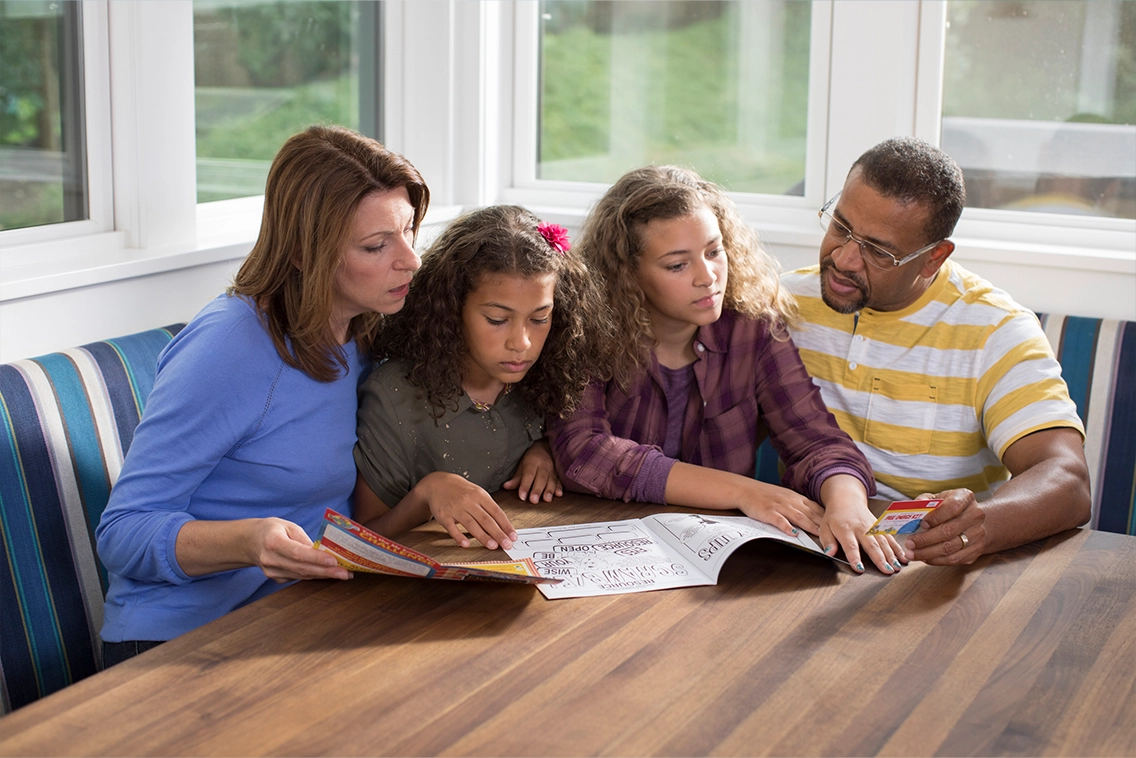 A family using printed workbooks from NTC to learn and grow